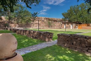 A stone pathway leading to a rustic building with a wooden fence and a clear blue sky. - Holiday Inn Canyon De Chelly by IHG (Chinle)
