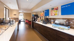 A breakfast area with a buffet setup, including a self-service station and a coffee bar.