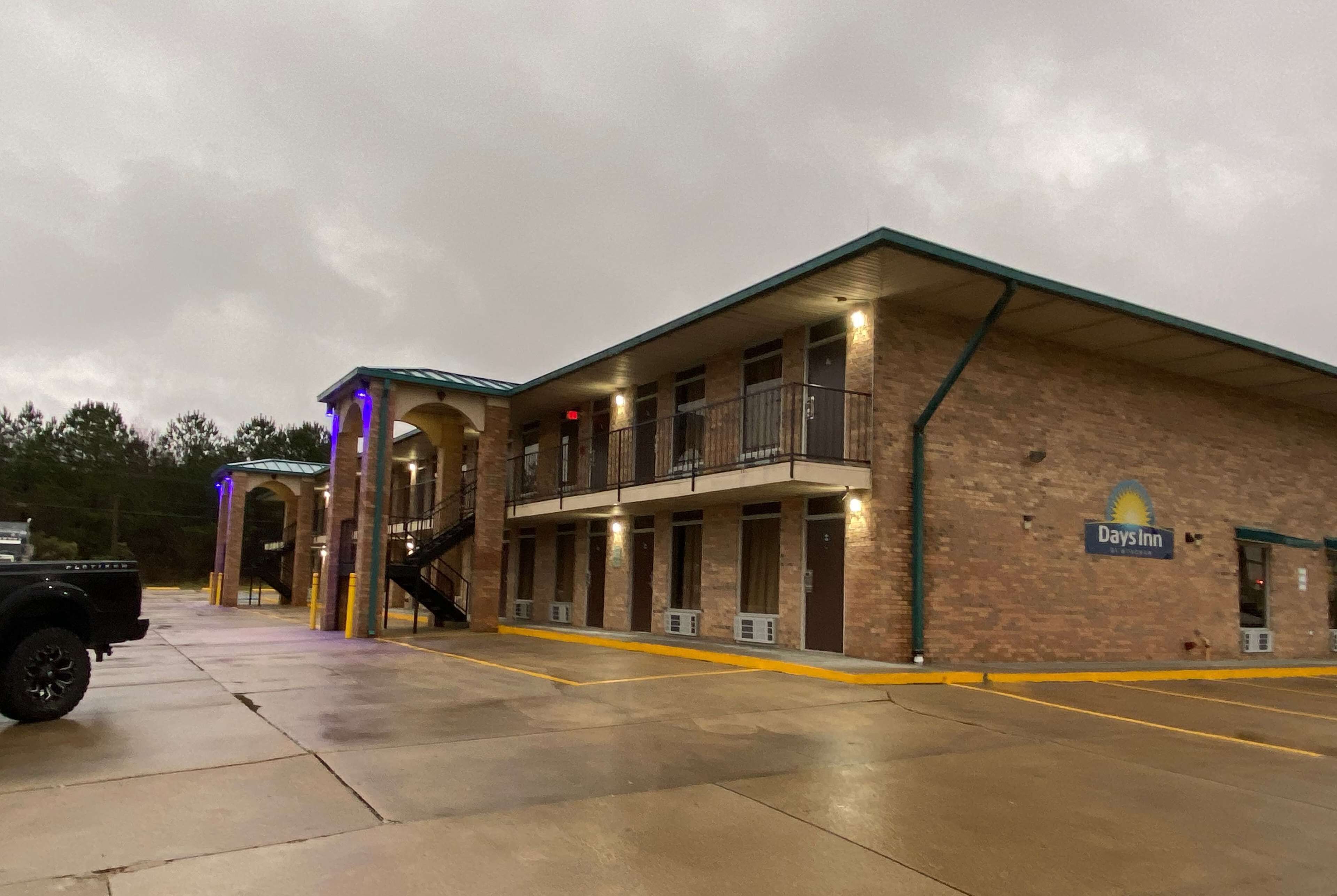 A Days Inn building with a brick facade, multiple balconies, and a covered entrance.