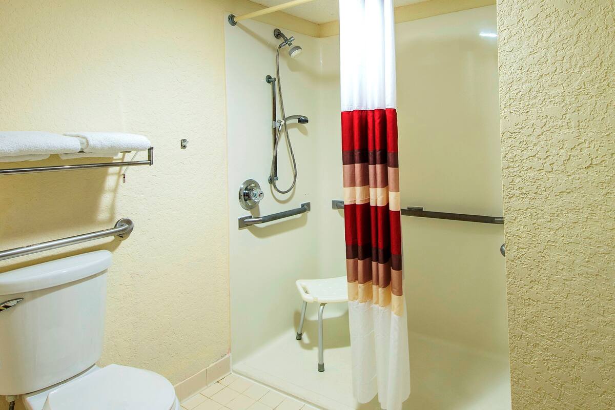 Ein Badezimmer mit Toilette, einer Duschkabine und einem Handtuchhalter.