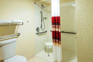 A bathroom with a toilet, a shower with a glass door, and a towel rack. - Red Roof Inn Lexington (Lexington)