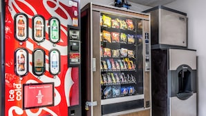 A vending machine with a variety of snacks and a Coca-Cola machine with multiple beverage options. - Red Roof Inn Lexington (Lexington)