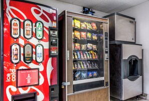Una máquina expendedora con diferentes bocadillos y una máquina de Coca-Cola con varias opciones de bebidas.
