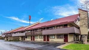 A motel with a two-story structure, a parking lot, and a clear sky. - Red Roof Inn Lexington (Lexington)