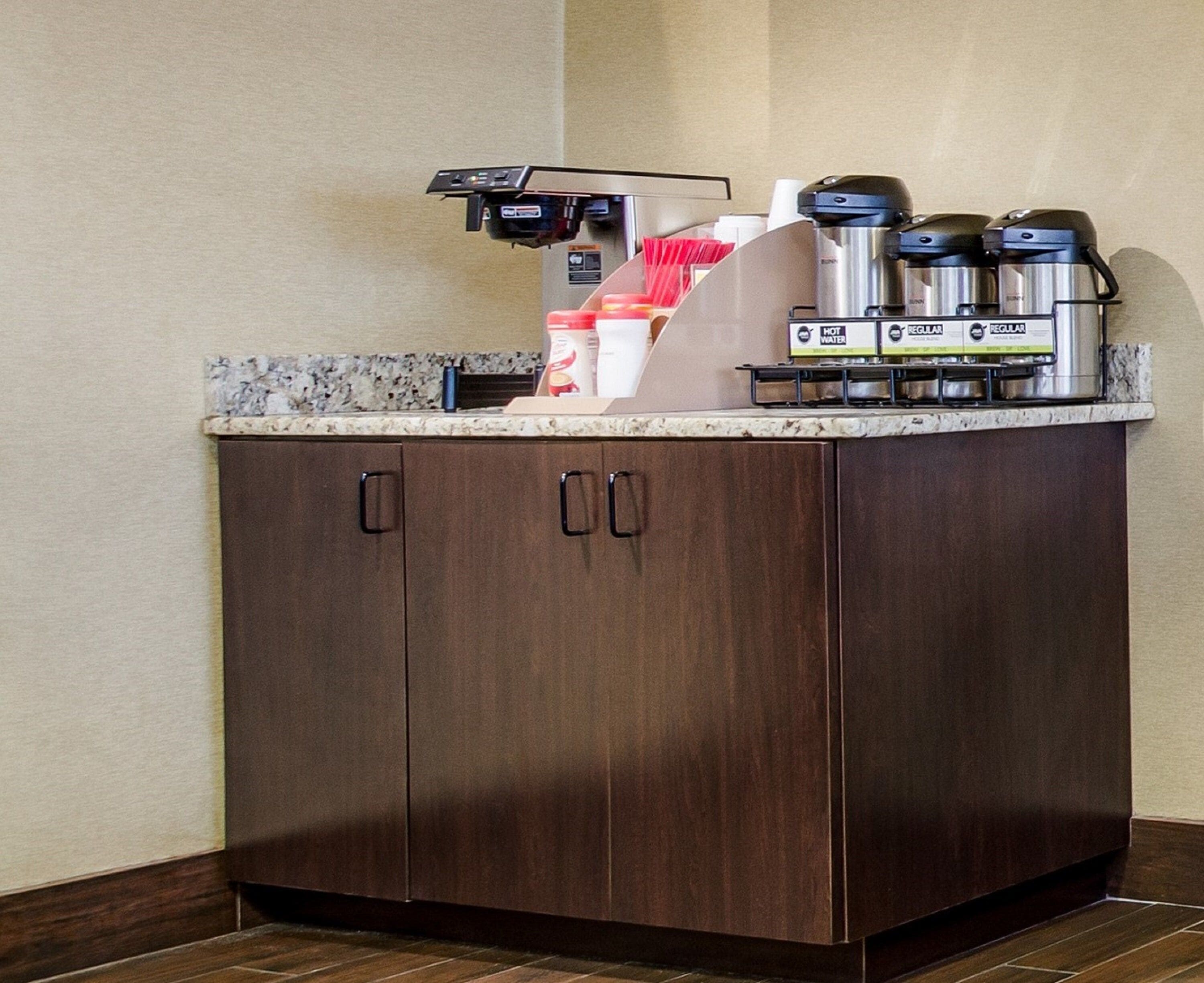 A kitchenette with a coffee maker, a water dispenser, and a coffee pot.