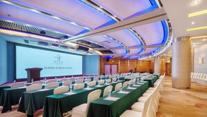 A conference room with rows of tables, chairs, and a projection screen. - Sunshine Hotel Shenzhen (Shenzhen)