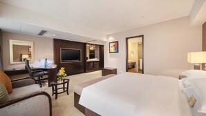 A hotel room with a large bed, a desk with a chair, a TV, a bathroom, and a small table with flowers. - Sunshine Hotel Shenzhen (Shenzhen)