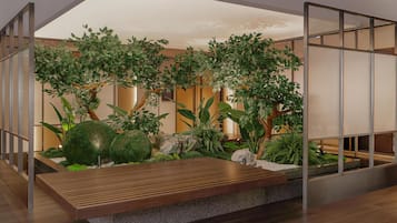 A modern indoor garden with a wooden bench, various plants, and a glass partition.