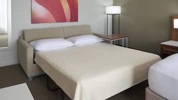 Habitación de hotel con cama, mesita de noche, lámpara y un cuadro en la pared.