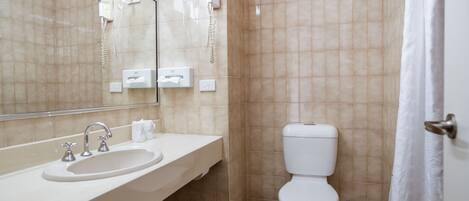 A bathroom with a sink, mirror, and toilet.