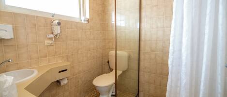 Une salle de bain comprenant des toilettes, un lavabo et un espace douche.