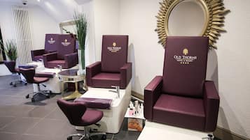 Experience a welcoming space at Old Thorns Hotel & Resort, where guests can enjoy a professional hair salon with a large mirror, reception desk, and hair care products.
