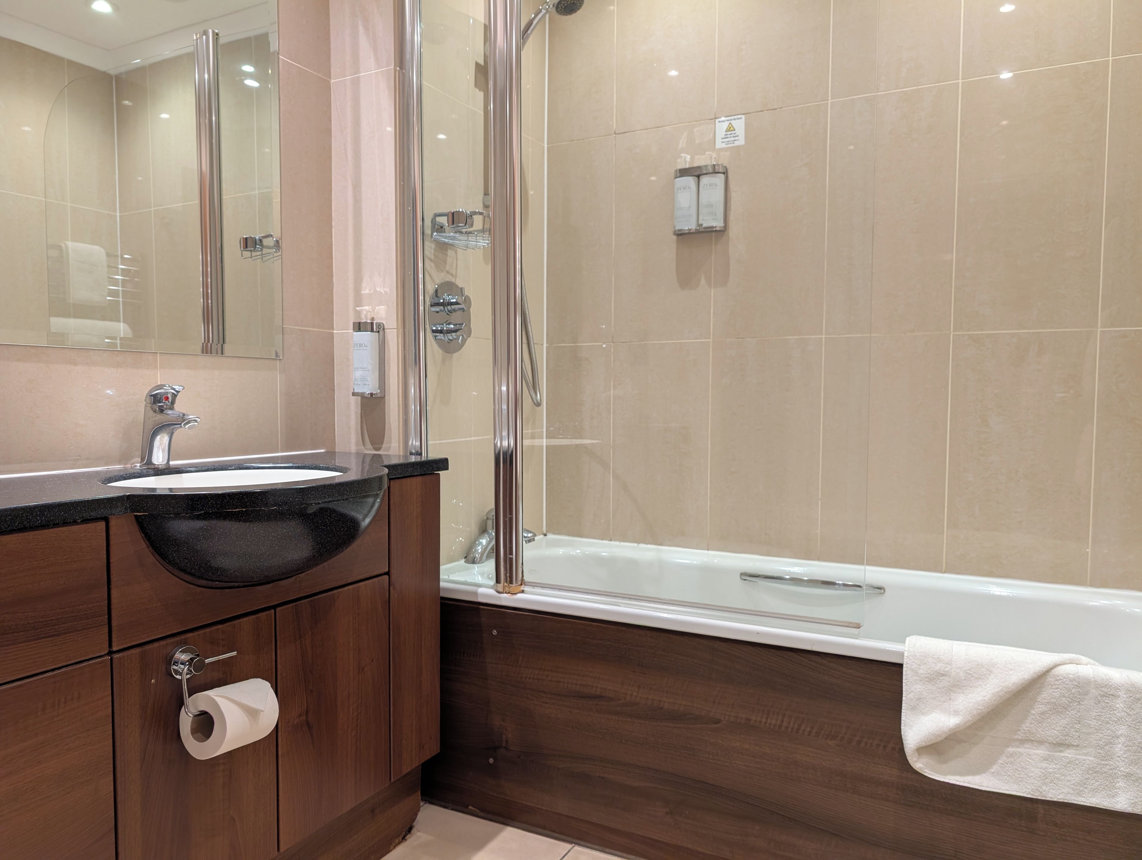 Un baño con lavamanos, espejo, ducha y bañera.