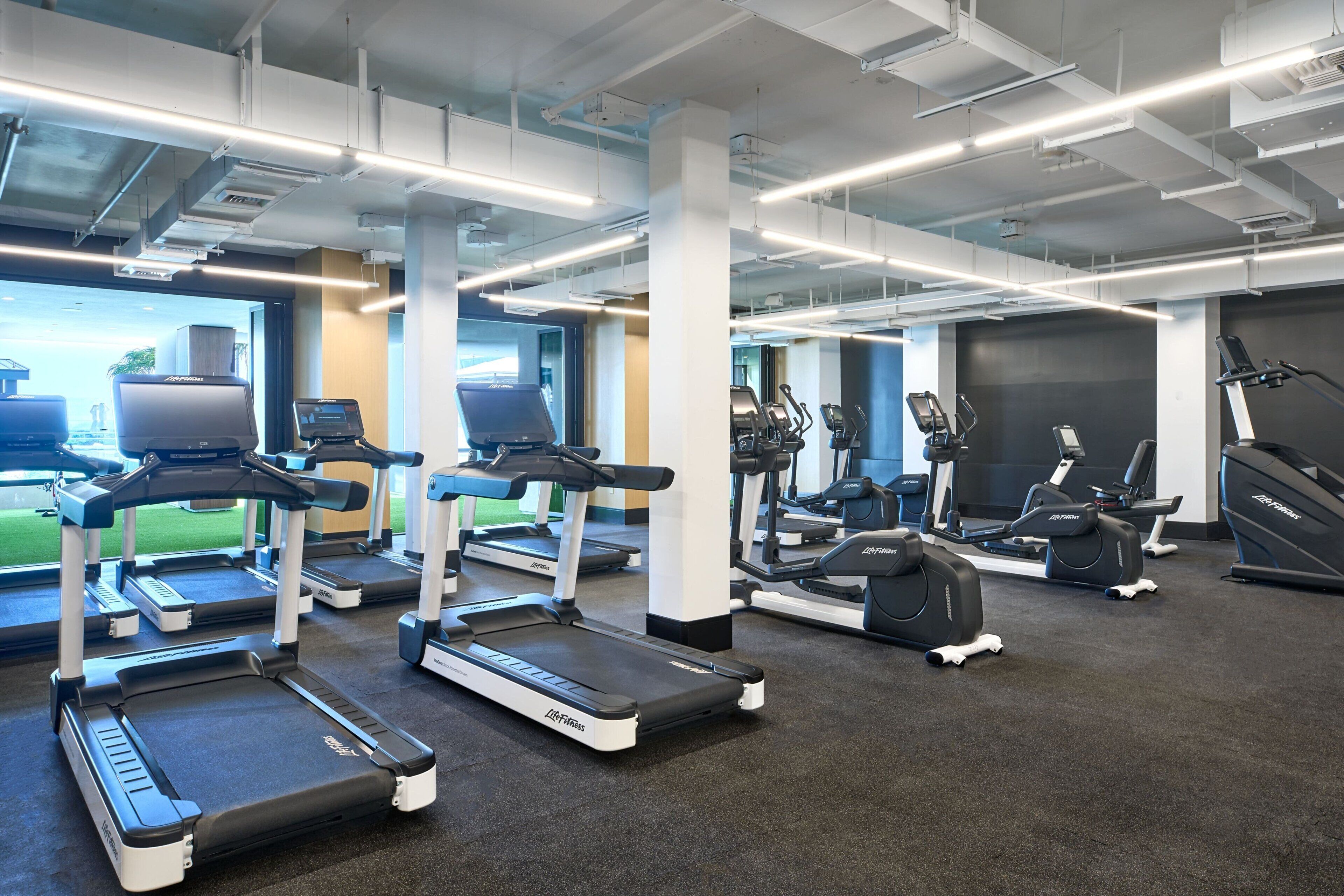 A gym with treadmills, elliptical machines, and stationary bikes.
