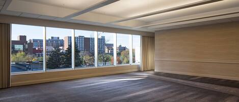 Amplia habitación con ventanas grandes que ofrecen vistas a la ciudad.