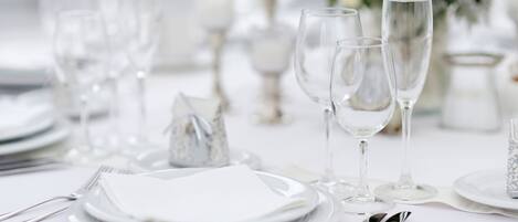 A table set for a formal event with clear glassware, plates, and silverware.