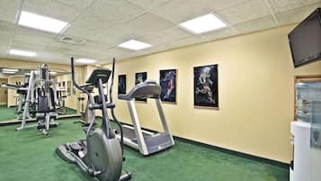 A gym with treadmills, elliptical machines, and weight equipment.