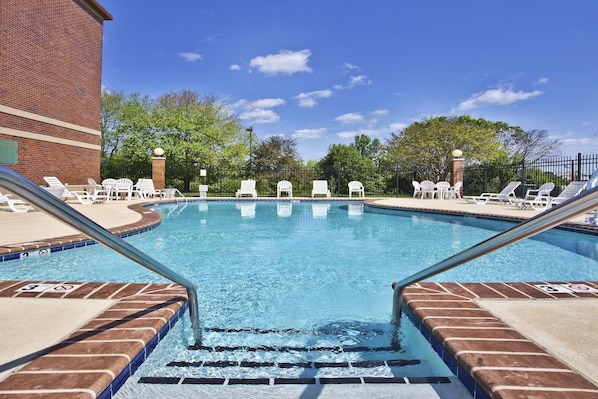 Una piscina al aire libre de temporada, sillones reclinables de piscina