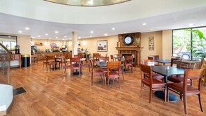 A spacious dining area with wooden flooring and multiple tables and chairs. - Baymont by Wyndham Knoxville/Cedar Bluff (Knoxville)