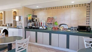A breakfast bar with a coffee machine, microwave, and various food items. - Days Inn by Wyndham Reno (Reno)