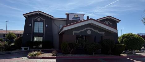 A Days Inn hotel with a modern design, featuring a prominent sign, a landscaped front yard, and a parking lot.