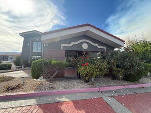A building with a modern architectural design, featuring a prominent entrance with a curved overhang and a large window.