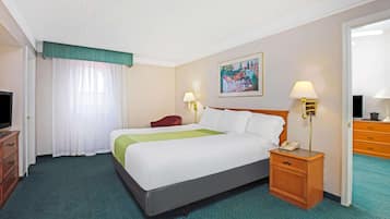 A hotel room with a bed, two bedside tables, a TV, a desk, and a chair.