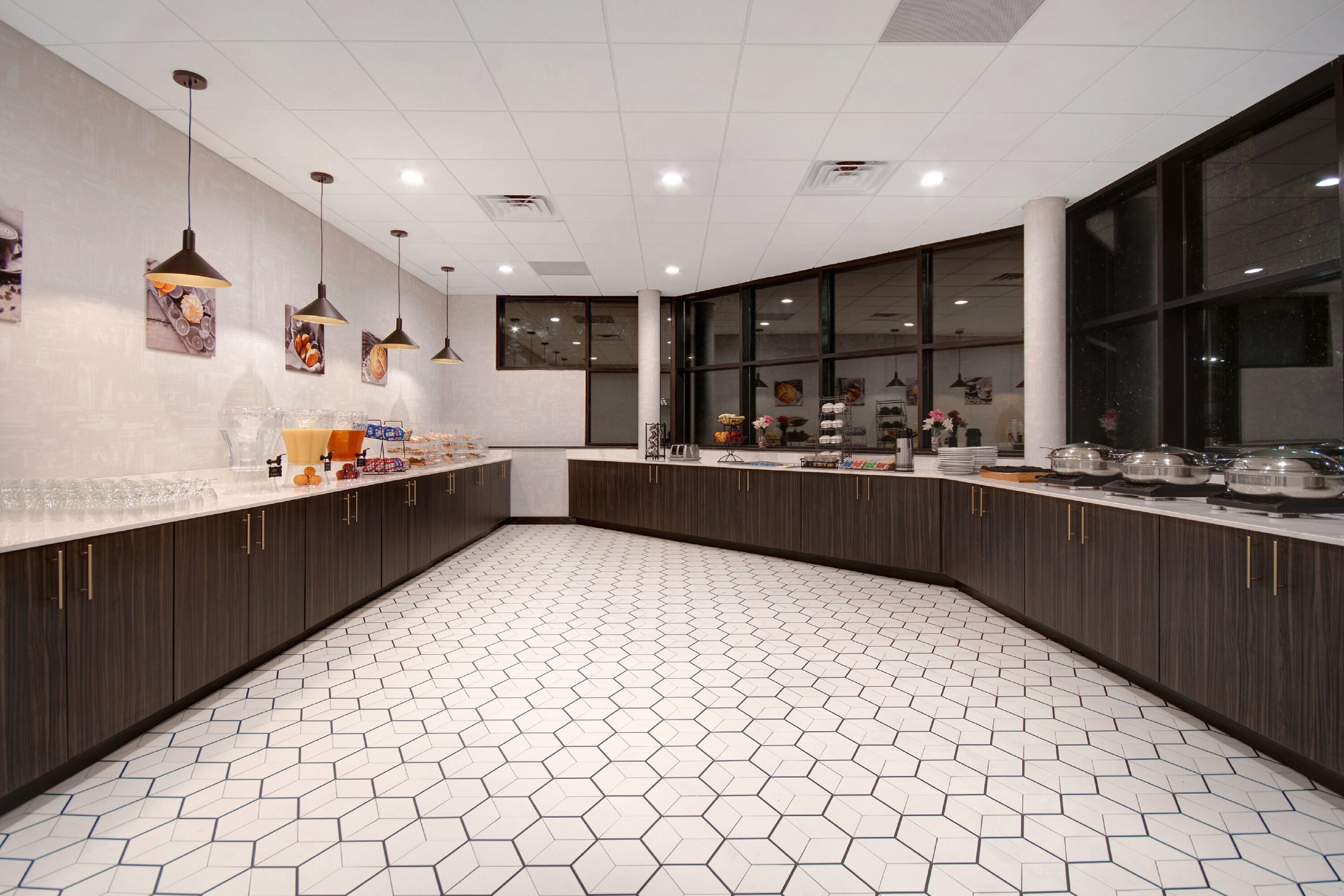 A modern kitchen with hexagonal patterned flooring, dark wooden cabinets, and pendant lighting.