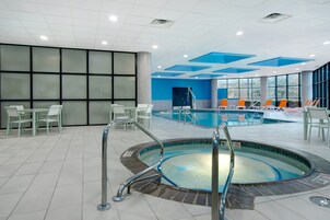 Una piscina techada, sillones reclinables de piscina