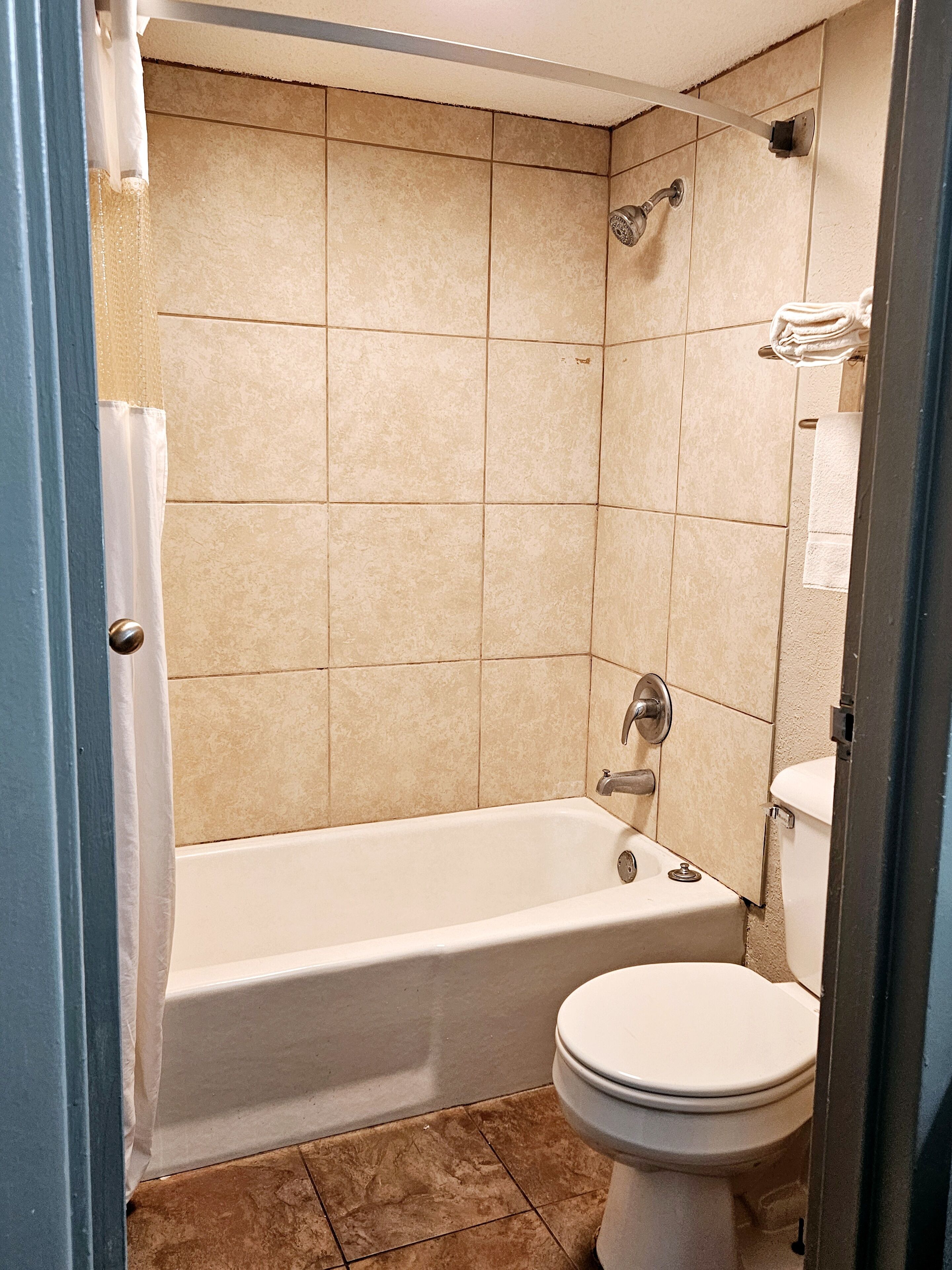 A bathroom with a bathtub, toilet, and shower.