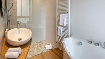 Ein modernes Badezimmer mit freistehender Badewanne, einem runden Waschbecken und einer Duschkabine aus Glas.