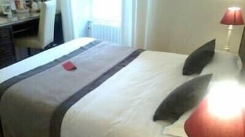 Une chambre d’hôtel avec un lit, un bureau et une lampe.