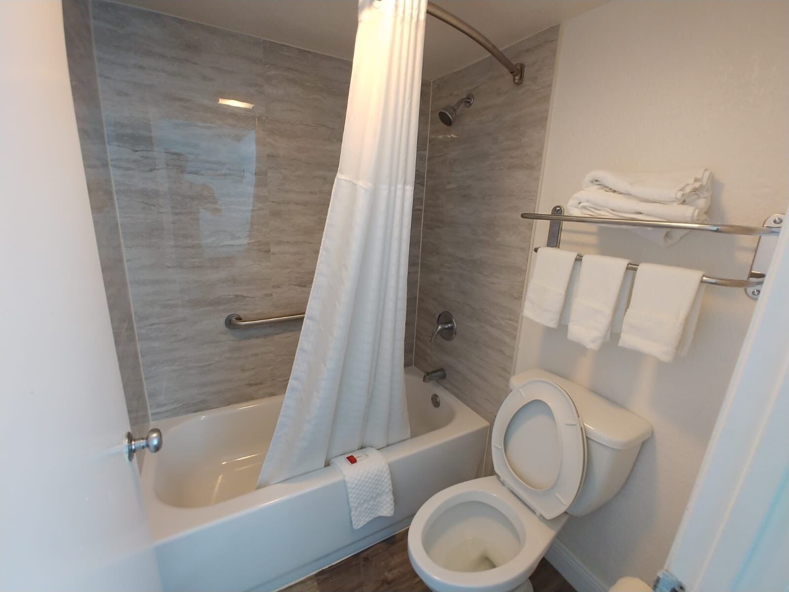 A modern bathroom with a bathtub, shower, and toilet.