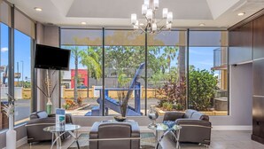A modern lobby with large windows, a chandelier, and seating areas. - Rodeway Inn Port Richey North (Port Richey)