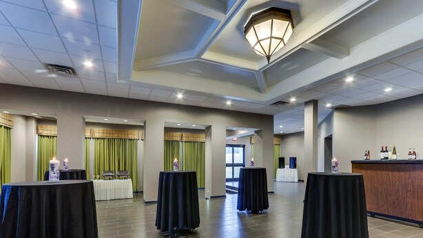 A spacious hotel lobby with high ceilings, recessed lighting, and a reception desk with a wine display. - Holiday Inn Staunton Conference Center by IHG (Staunton)