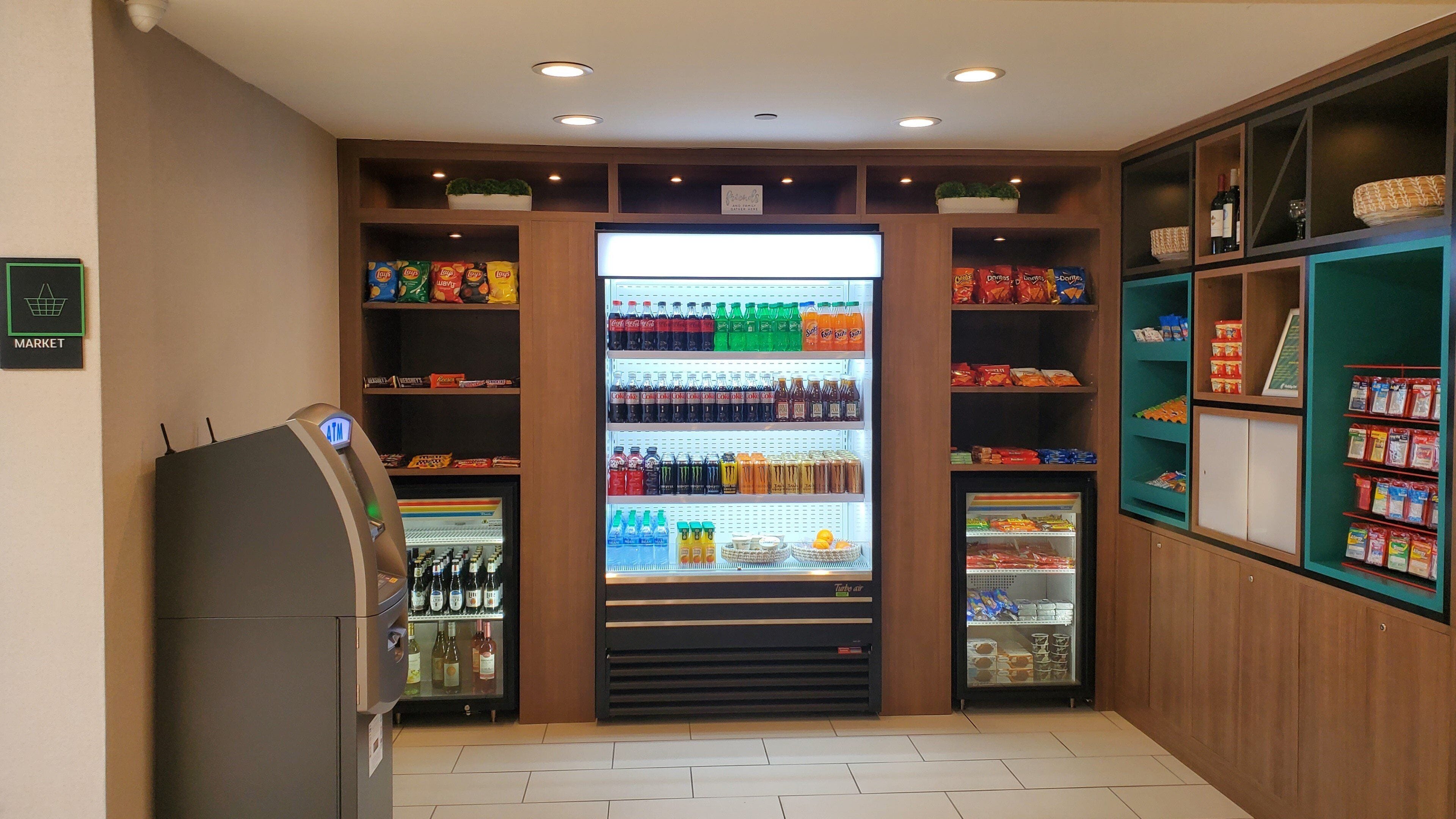 A self-service beverage and snack vending area with multiple shelves stocked with various drinks and snacks.