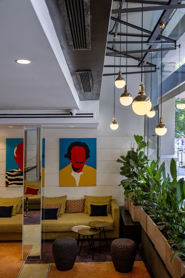 Um interior moderno com um sofá, uma mesa pequena e luminárias pendentes.