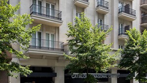 A multi-story hotel with balconies, a storefront, and a parking garage entrance. - Catalonia Diagonal Centro (Barcelona)