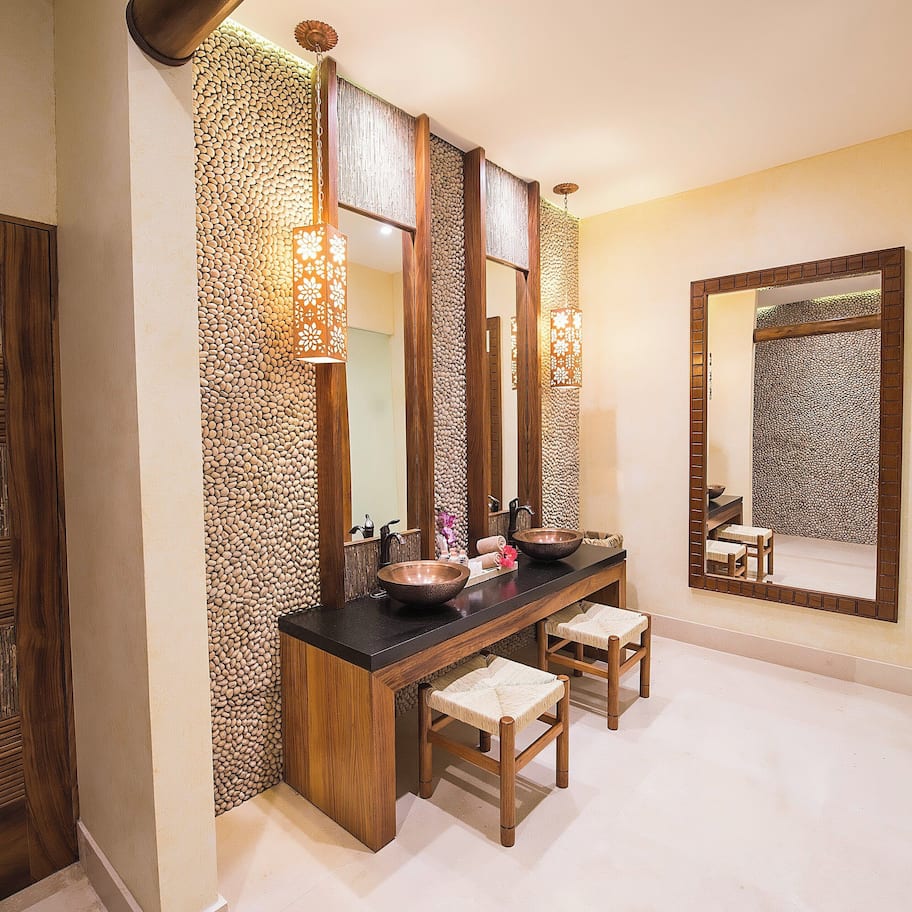 A bathroom with a wooden vanity, two sinks, and a large mirror.