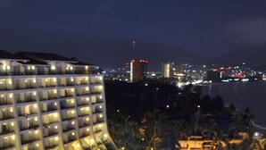 Een hotel met meerdere verdiepingen, een zwembad en palmbomen.