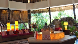 A lobby with wicker furniture, a reception desk, and a large rock feature. - Fiesta Americana Puerto Vallarta All Inclusive & Spa (Puerto Vallarta)