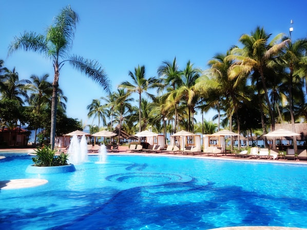 Una piscina al aire libre, cabañas de piscina (de pago), sombrillas