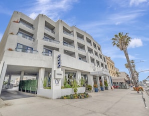 A multi-story hotel with a modern design, featuring a prominent 'PARKING' sign and a 'HOTEL' sign.