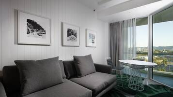 A modern living room with a grey sofa, a round table, and three framed pictures on the wall.