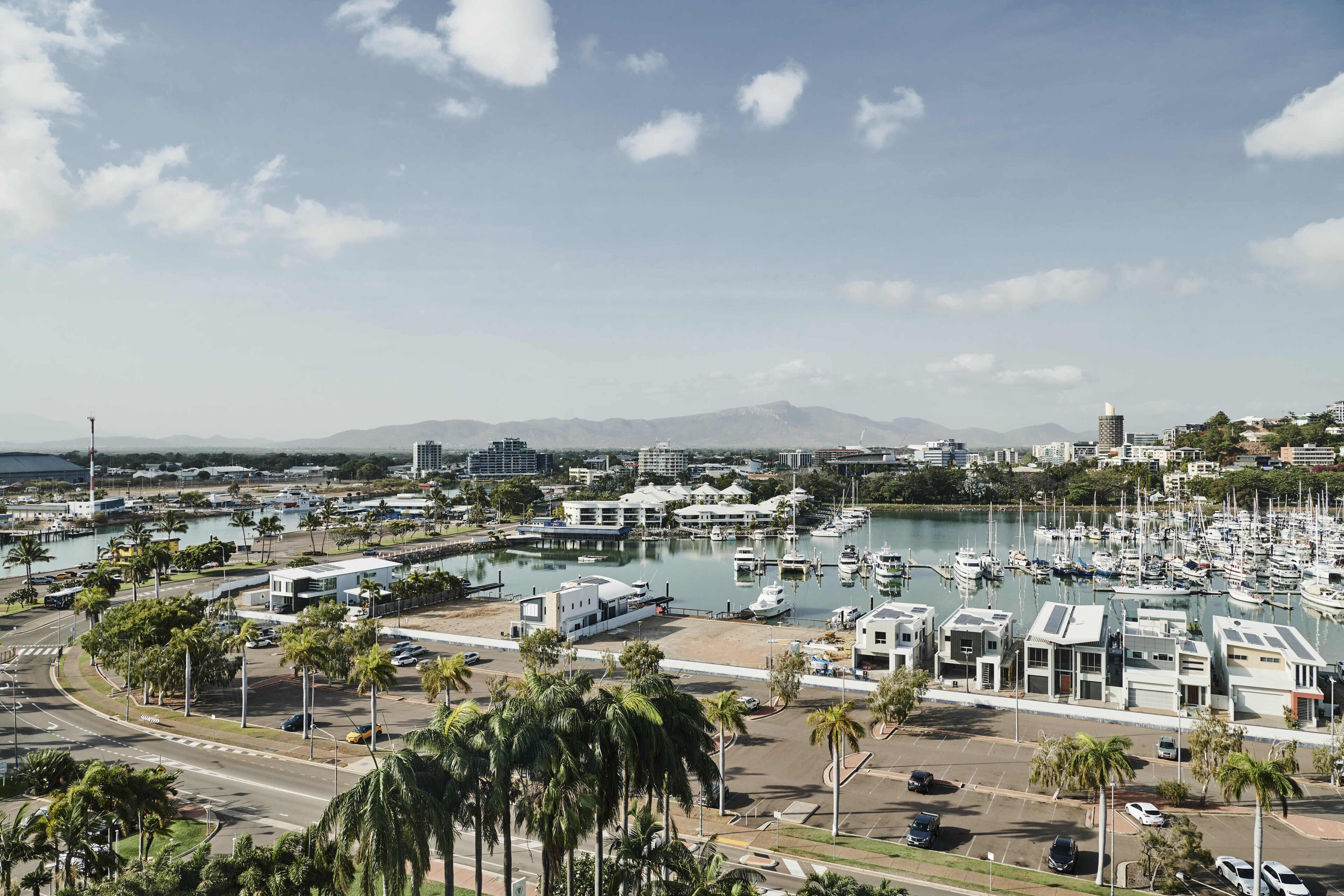 A marina with boats, a road, and buildings.