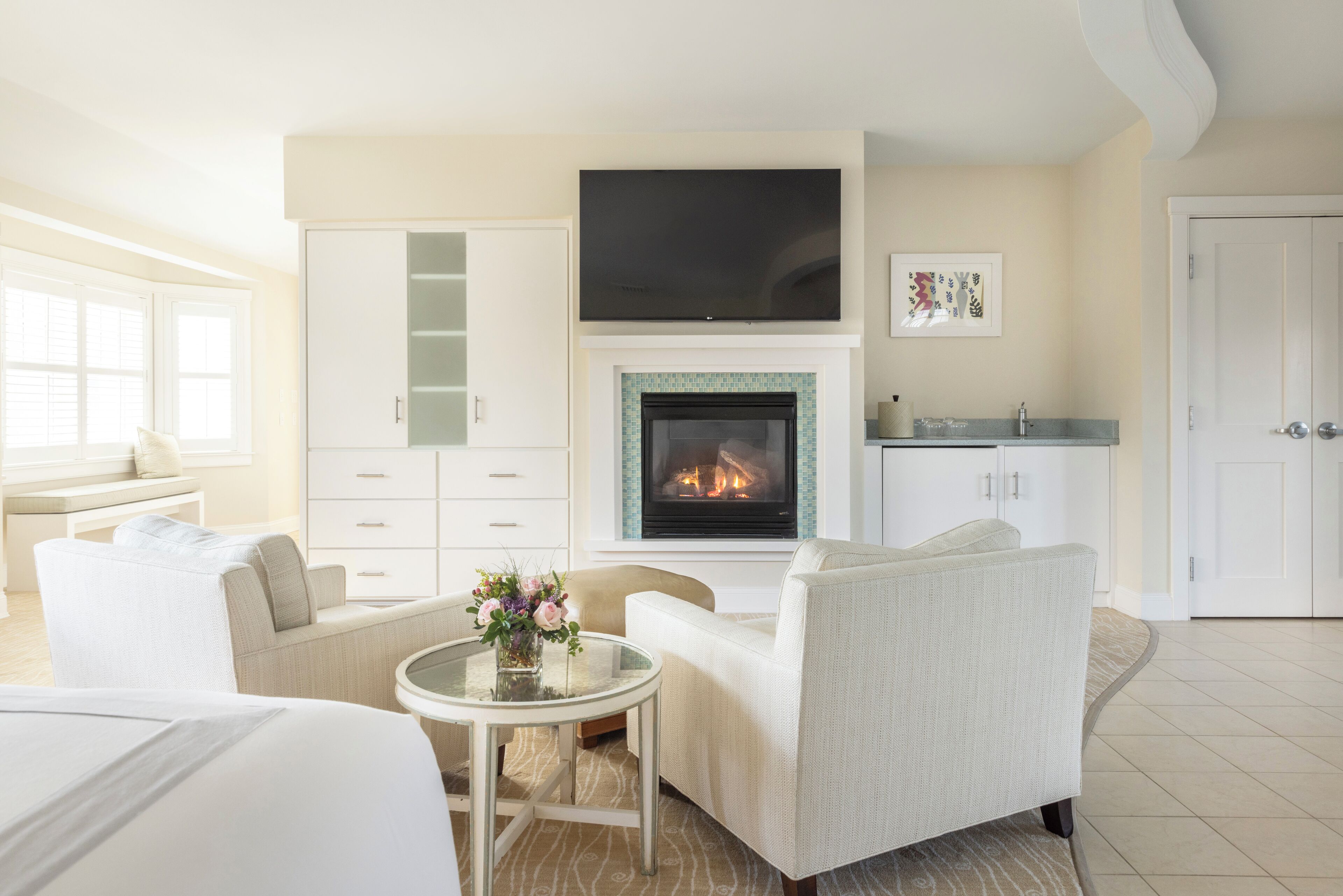 A modern living room with a fireplace, comfortable seating, and a flat-screen TV.
