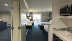 A hotel room with a kitchenette, a bed, a desk, and a bathroom. - The Pacific Inn (Seal Beach)