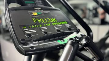 A stationary exercise bike with a digital display showing "PILOT" and various workout metrics.