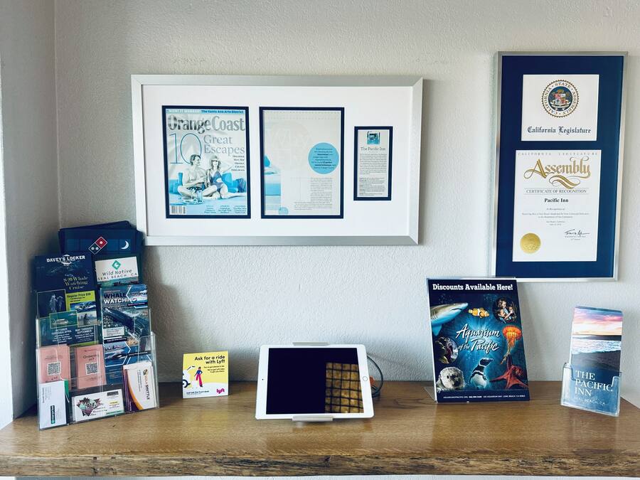 Een bureau met reisbrochures, een tablet en een lijst met een onderscheiding.