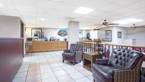 A spacious lobby with a breakfast bar, seating area with leather chairs, and a tiled floor. - Baymont by Wyndham Hays (Hays)